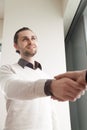 Young smiling businessman shaking female hand standing in office Royalty Free Stock Photo