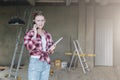 Young smiling businesswoman builder,engineer, architect,designer in workshop, talking on cell phone Royalty Free Stock Photo