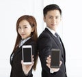 smiling businesswoman and businessman showing smart phone