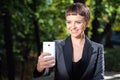 Young smiling businesswoman taking photo with her phone. outdoor Royalty Free Stock Photo