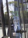 Young smiling businesswoman using the phone on the other side of a glass door Royalty Free Stock Photo