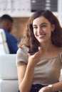 Young Smiling Businesswoman Working At Desk In Office Talking Into Mic Of Mobile Phone Royalty Free Stock Photo