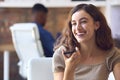 Young Smiling Businesswoman Working At Desk In Office Talking Into Mic Of Mobile Phone Royalty Free Stock Photo