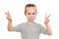 Young smiling caucasian boy with lollipop in mouth shows victory sign Royalty Free Stock Photo