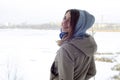 A young and smiling Caucasian girl looks around the horizon line between the sky and the frozen lake Royalty Free Stock Photo