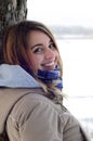 A young and smiling Caucasian girl looks around the horizon line between the sky and the frozen lake Royalty Free Stock Photo