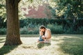 Young smiling Caucasian mother and laughing boy toddler son sitting on grass in park. Family mom and child hugging having fun Royalty Free Stock Photo