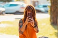 Young smiling Caucasian tanned woman sitting on bench and using smartphone. Girl take selfie. Concept of psychology and Royalty Free Stock Photo