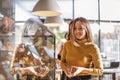 Young hungry woman choosing food while standing near showcase at bakery shop