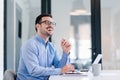 Young smiling cheerful confident businessman entrepreneur talking to satisfied customer or to colleague coworker employee while