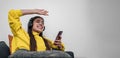 Young smiling cheerful girl woman listening to music from smartphone wearing wireless headset headphones and dancing with her arms Royalty Free Stock Photo