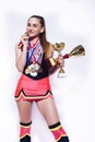 Young smiling cheerleader girl with golden cups and price medals isolated on white background, lifestyle sport people Royalty Free Stock Photo