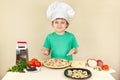 Young smiling chef in chefs hat enjoys cooking tasty pizza Royalty Free Stock Photo