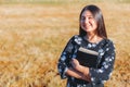 Young smiling christian woman holding a bible under her arm in the field. Sola scriptura. Copy space Royalty Free Stock Photo