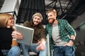 Young smiling colleagues in office using tablet computer Royalty Free Stock Photo