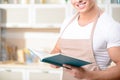 Young smiling cook is reading a cookbook