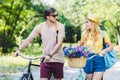 young smiling couple with backpacks and bicycles