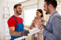 Young smiling couple and builder handyman talking about details