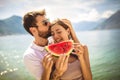 Smiling couple eating watermelon on the beach having fun Royalty Free Stock Photo