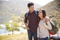 Young smiling couple embracing next to bench in a park Royalty Free Stock Photo