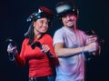 Young smiling couple having fun together, play with VR headsets and controllers. Royalty Free Stock Photo