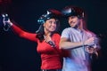 Young smiling couple having fun together, play with VR headsets and controllers. Royalty Free Stock Photo