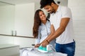 Young couple at home doing hosehold chores and ironing Royalty Free Stock Photo