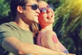 Young smiling couple in sunglasses sitting in a park in sunny day. friendship, leisure, summer concept