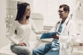 Young Doctor Consulting Beautiful Woman in Clinic.