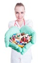 Young smiling doctor holding many pills in her palms