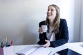 Young smiling entrepreneur woman holding a mobile phone while working at home Royalty Free Stock Photo