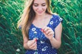 European girl holds a daisy flower and tears off the petals Royalty Free Stock Photo