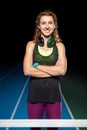 Young smiling female athlete standing near hurdle Royalty Free Stock Photo