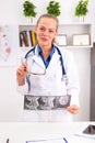 Young smiling female doctor examining patient`s MRI or x-ray of human head. Royalty Free Stock Photo