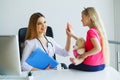 Young smiling female doctor and her little patient with teddy be Royalty Free Stock Photo