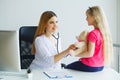 Young smiling female doctor and her little patient with teddy be Royalty Free Stock Photo