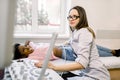 Young smiling female doctor moving ultrasound transducer on African woman belly and kidneys while looking at screen in Royalty Free Stock Photo