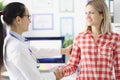 Young smiling female doctor shaking hand to woman patient Royalty Free Stock Photo