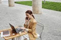 Young smiling female freelancer or solopreneur speaking on mobile phone Royalty Free Stock Photo