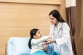 Young smiling female pediatrician doctor and child patient with teddy bear in the health medical center Royalty Free Stock Photo