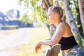 Young smiling female resting after an active fitness training while leaning over a wooden fence or bench, satisfied fit Royalty Free Stock Photo