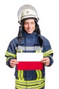 Young smiling firefighter looking to the camera and holding paper sheet with polish flag