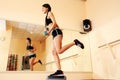 Young smiling fit woman doing exercises with dumbells on step board Royalty Free Stock Photo