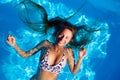 Young smiling fitted woman in bikini relax chilling, swimming on back in clear water in pool. Hot pretty girl in Royalty Free Stock Photo