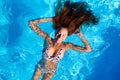 Young smiling fitted woman in bikini relax chilling, swimming on back in clear water in pool. Hot pretty girl in Royalty Free Stock Photo