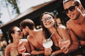 Young Smiling Friends with Cocktails at Poolside Royalty Free Stock Photo