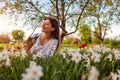 Young gardener picks daffodil flowers in spring garden. Happy woman smelling narcissus blooms cut with pruner. Gardening Royalty Free Stock Photo