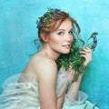 Young smiling girl with blue flowers on light blue background. Spring beauty portrait