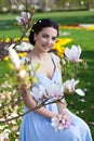 Young smiling girl in evening dress with magnolia