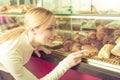 Young smiling girl gladly choosing pastry